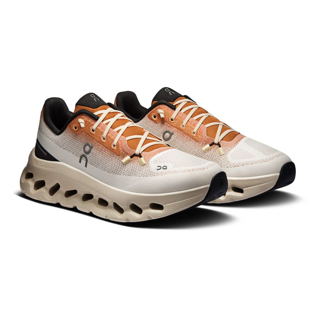 A single On Cloudrunner sneaker shown in a side profile view against a plain white background. The shoe features a light beige and white mesh upper, peach-colored laces, a black heel accent, and a thick, sculpted beige midsole with distinctive cutouts.