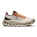 A single running shoe from the brand On, shown in profile against a plain white background. The shoe features a light beige and white mesh upper with a peach-to-orange gradient overlay, black accents on the heel and tongue, and a thick, sculpted off-white midsole with black cutouts.
