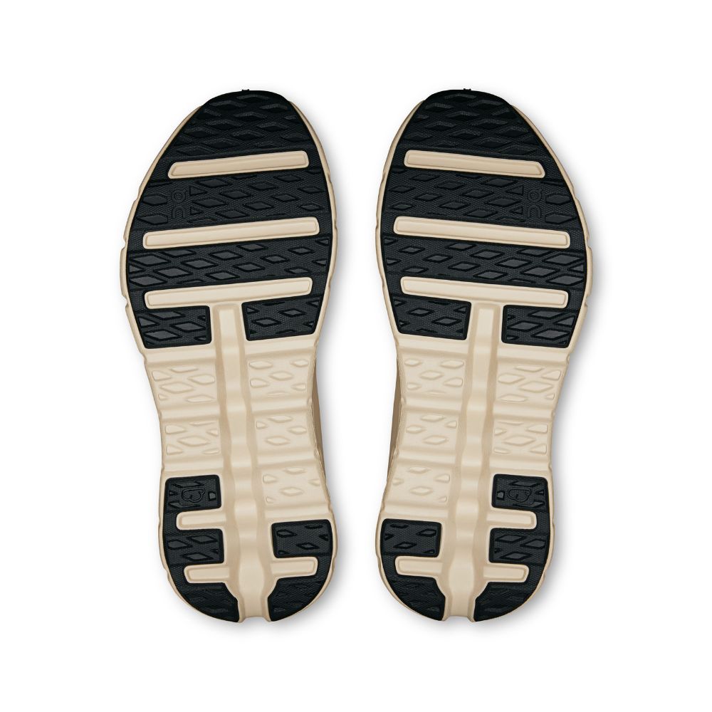 A pair of athletic shoe soles shown from the bottom, featuring a black textured tread pattern on the upper half and a beige cushioned midsole with horizontal support bars on the lower half, set against a plain white background.