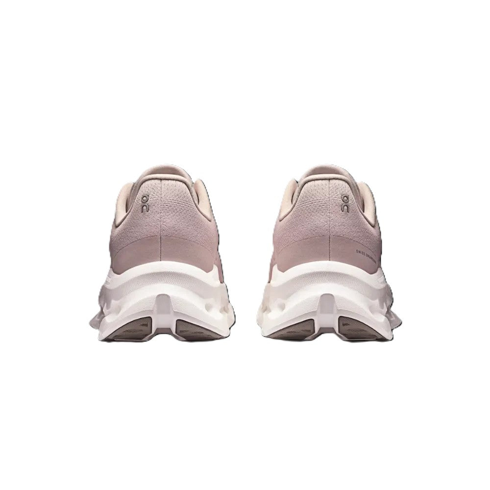 A pair of chunky platform sneakers shown from the back, featuring a dusty pink textured upper and a thick white sole, set against a plain white background.