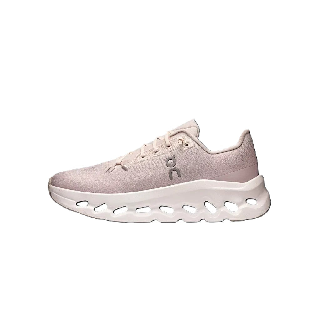 A single light pink and white athletic sneaker shown in a side profile on a solid white background. The shoe features a textured pink upper, matching pink laces, a white midsole with circular cutouts, and a small gray 'on' logo on the side.