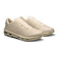 A pair of low-top athletic sneakers in a monochromatic cream and beige colorway, shown from a three-quarters angle on a white background.