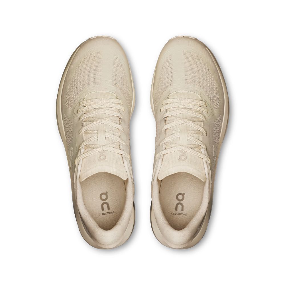 A pair of On Cloudrunning sneakers in a light cream/off-white color, shown from a top-down view on a solid white background.