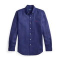 A long-sleeve button-down shirt in a textured indigo blue fabric, featuring a small embroidered red polo player logo on the left chest. The shirt is displayed flat against a clean white background.