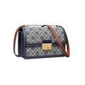 A Tory Burch crossbody bag featuring navy blue and white monogram canvas, navy blue leather trim, a gold-tone turn-lock clasp, and a brown leather shoulder strap, shown against a plain white background.