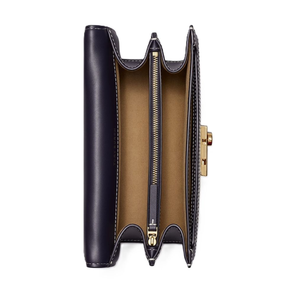 A navy blue leather clutch wallet shown open, displaying its tan interior lining, gold-tone zipper, and gold-tone clasp on a plain white background.