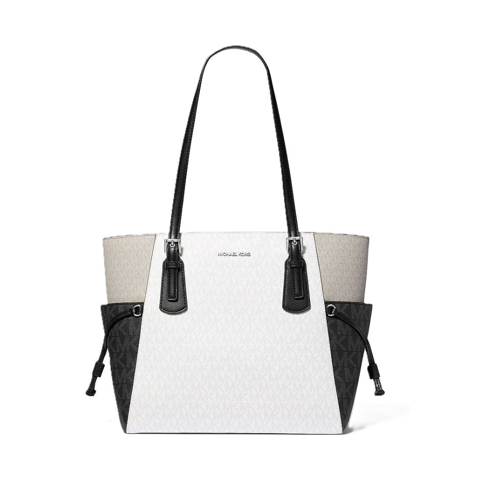 Michael Kors tote bag in white monogram canvas with black leather trim, double shoulder straps, and black side pockets, shown on a plain white background.