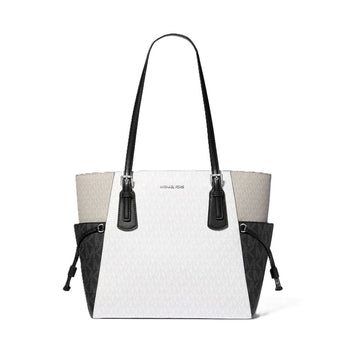 Michael Kors tote bag in white monogram canvas with black leather trim, double shoulder straps, and black side pockets, shown on a plain white background.